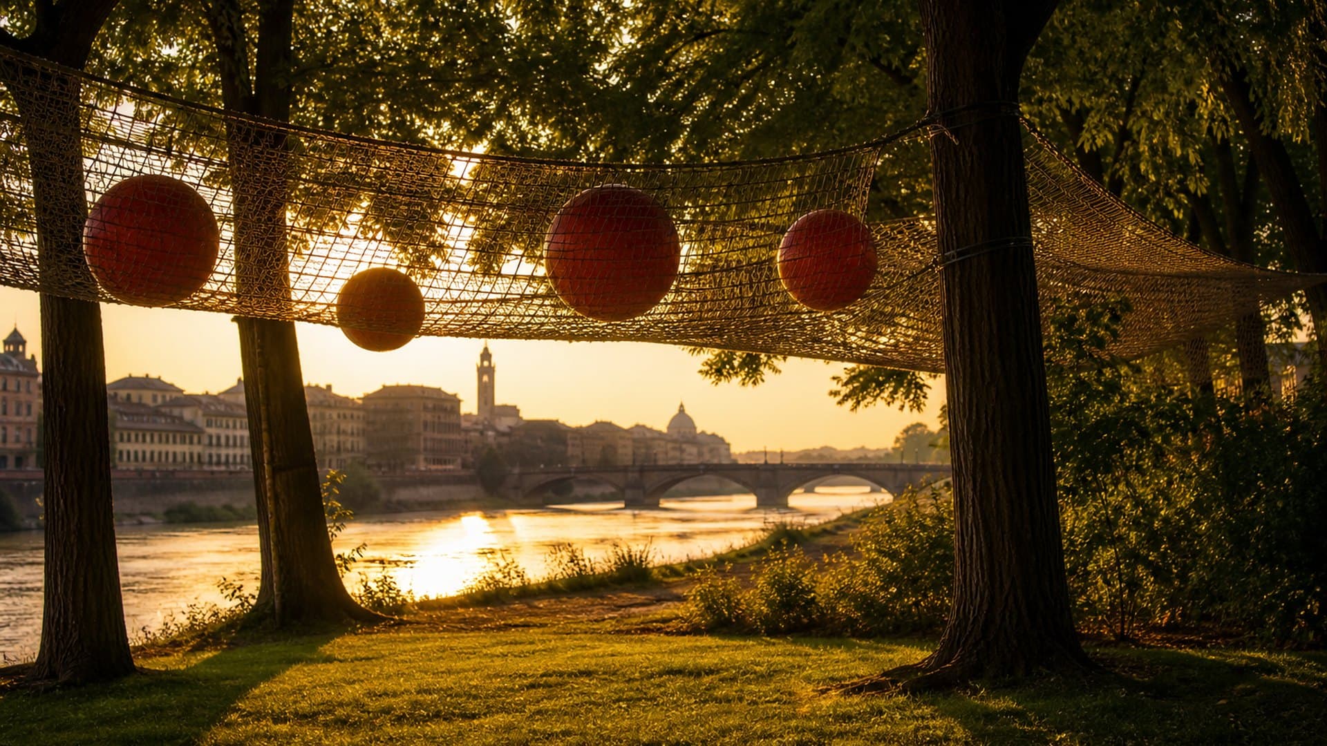 A rope net strung between trees on the Florence riverbank at golden hour, red balls resting in the mesh and the Arno beyond